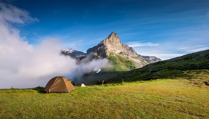 cloudscape covering with fog the peak of a famous mountain in pyrenees from a camping scenic view