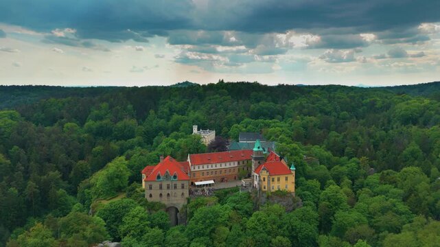 aerial footage showcasing the majestic Hrub&aacute; Sk&aacute;la Castle nestled amidst the lush forests and sandstone cliffs of Bohemian Paradise Česk&yacute; r&aacute;j in the Czech Republic. This historic Renaissance castle, a