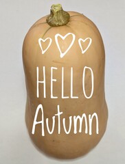 Logo con texto manuscrito hello autumn con corazones en una calabaza para felicitaciones y tarjetas © teracreonte