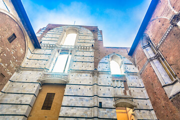 Obraz premium Photo of stone walls and historic gateway in Siena showing medieval architecture, rustic facades, cultural heritage and authentic Tuscan atmosphere in the heart of Italy