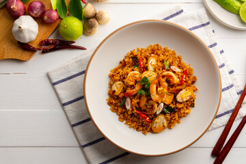 Tom Yum Fried Rice,Thai fried rice with shrimp and Straw mushroom with tom yum sauce in white plate.Top view.