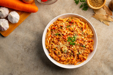 Fettuccine pasta with Ground meat and tomato,spaghetti with a meat based bolognese tomatoes,served on white plate with parmesan cheese.Top view.