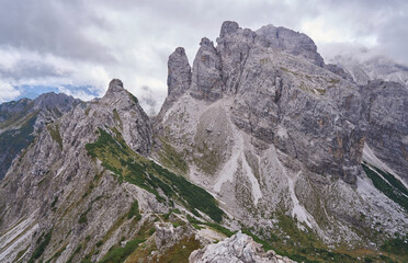 The mountain landscape with Mus pass in wild and inaccessible Friuli Dolomites, UNESCO Heritage Site. Nature reserves Dolomiti Friulane and Forra del Cellina. Trekking. Autumn, fog, rain clouds.