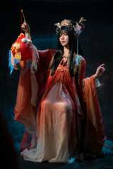 Asian woman in traditional red costume with golden details