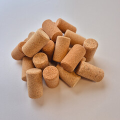 A close-up of multiple cork cylinders placed on a white tabletop, highlighting the natural grain, color, and texture of cork material.
