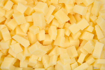 A detailed close-up shot shows a horizontal pattern completely filled with yellow cheese cubes, creating a textured background