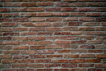 Fototapeta premium A brick wall with a rough texture and a reddish-brown color