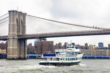 Obraz premium Brooklyn Bridge over East River with Manhattan skyline and boat
