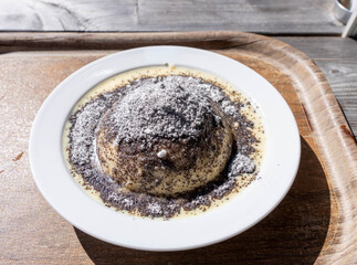 Austrian Germknödel Yeast Dumpling in a Table with Sugar and Sauce on Top