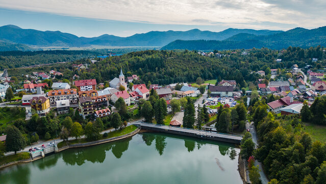 Scenic aerial view of Fužine (Fuzine) and Lake Bajer in Gorski Kotar, Croatia. Picturesque town, green forested hills, and a bridge over calm mountain water