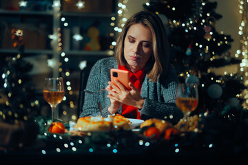 Serious Woman Checking her Phone Waiting for her Guests to Arrive. Worried party host awaiting for family to gather for dinner 
