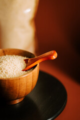 Couscous grains in a wooden bowl with a spoon ready for cooking preparation