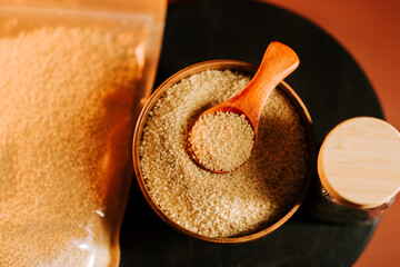 Uncooked couscous in a bowl with a wooden spoon ready for cooking or meal preparation