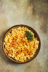 risotto with shrimp, in a bowl, on a textured surface, with a side dish of fresh coriander, homemade, no people,