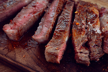 medium rare, sliced rib eye steak, grilled cowboy steak, on a chopping board, close-up, homemade, top view, no people,