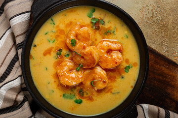 Creamy shrimp curry with spices, garnished with herbs, on a textured background, homemade , no people,