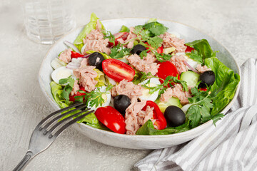 salad with canned tuna, vegetable salad with quail eggs, lettuce and romaine leaves, red onion, cherry tomatoes, olives, keto food, healthy eating,