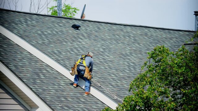 Roofers finishing roof repair putting the shingles in right order and nailing them on the house roof. Element of roof renovation