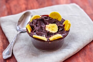 The most authentic Brazilian açaí, Euterpe oleracea, with banana in a minimalist bowl and compatible environment. Superfood energy and vitamins