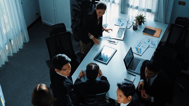 Top view of smart executive manager financial graph to diverse team while group of multicultural business people planning marketing strategy by using stock investment chart at meeting. Directorate.