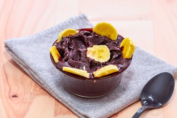 The most authentic Brazilian açaí, Euterpe oleracea, with banana in a minimalist bowl and compatible environment. Superfood energy and vitamins