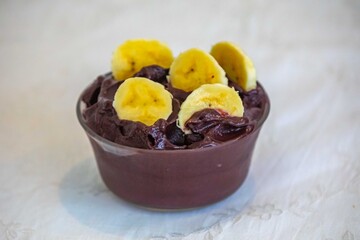 The most authentic Brazilian açaí, Euterpe oleracea, with banana in a minimalist bowl and compatible environment. Superfood energy and vitamins