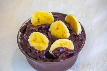 The most authentic Brazilian açaí, Euterpe oleracea, with banana in a minimalist bowl and compatible environment. Superfood energy and vitamins