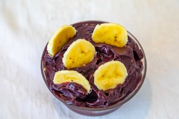 The most authentic Brazilian açaí, Euterpe oleracea, with banana in a minimalist bowl and compatible environment. Superfood energy and vitamins