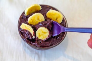 The most authentic Brazilian açaí, Euterpe oleracea, with banana in a minimalist bowl and compatible environment. Superfood energy and vitamins