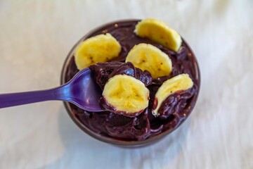 The most authentic Brazilian açaí, Euterpe oleracea, with banana in a minimalist bowl and compatible environment. Superfood energy and vitamins