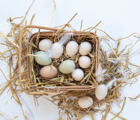 Obraz premium Small Bantam Eggs in Straw in Wooden Basket