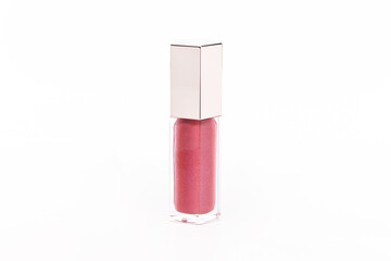 A small bottle of pink lip gloss sits on a white background