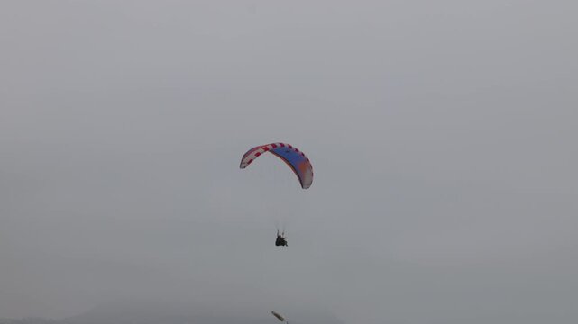 Paragliders fly in cloudy weather over the coast of Lima's Miraflores district.