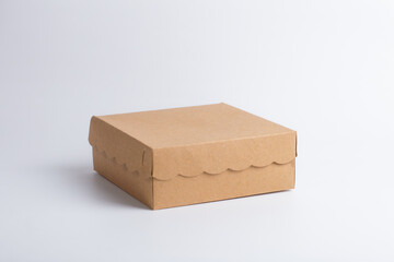 3/4 view cardboard box mockup with scalloped edges. Isolated brown kraft paper packaging on white background for e-commerce shipping, delivery, or branding design.
