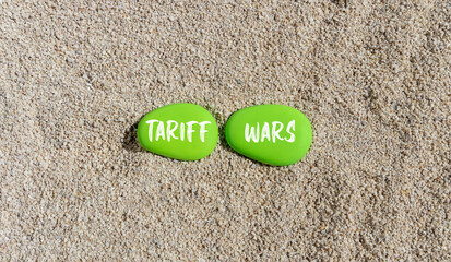 Trade tariff wars symbol. Concept word Tariff wars on beautiful green stones. Sea sand beach....