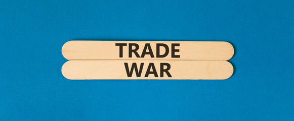 Trade war symbol. Concept word Trade war on beautiful wooden sticks. Beautiful blue paper...