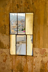 Distressed Interior Wall Framing a View of an Old City Quarter