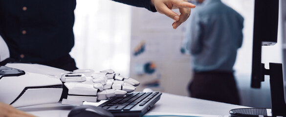A focused interaction between a human and a robot in a modern office setting, highlighting collaboration and the use of technology for data analysis and productivity.Noogenesis
