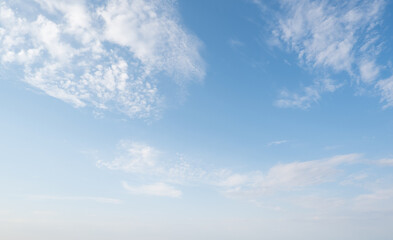 Clear sky with scattered white clouds. The clouds vary in size and shape, creating a serene atmosphere. Background light blue