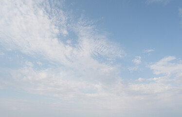 Clear sky with scattered white clouds. The clouds vary in size and shape, creating a serene atmosphere. Background light blue