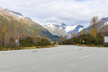 Remote Alaskan Road Infrastructure in Chugach Mountains. Mountain highway in Alaska with tall snow poles and reflective road markers for navigation during heavy snowfall and storms.