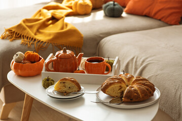 Autumnal living room decor with pumpkins, tea set and cake.