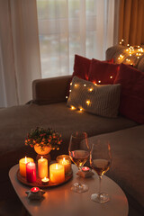 Cozy evening scene with candles, wine glasses and warm lighting.
