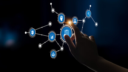 This image portrays a hand interacting with a futuristic digital interface featuring various icons connected by lines, representing technology and information exchange. Tessel
