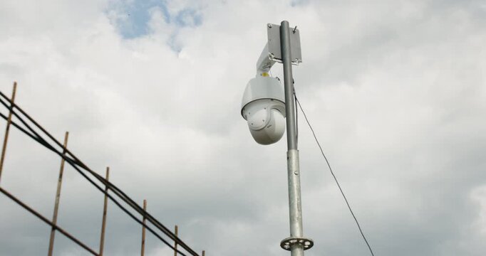 Surveillance camera monitoring clouds over construction site during afternoon hours
