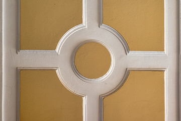 Symmetrical wall detail with circular and cross pattern
Decorative architectural detail with geometric circle and cross design in beige and white colors.
