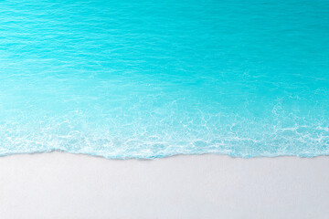 Serene turquoise waters gently meet soft white sands at a tranquil beach on a sunny day