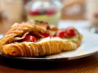 close-up of a savory croissant filled with tomatoes and cheese
