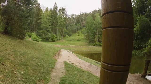 Footage captures the tranquil beauty of Prachovsk&eacute; sk&aacute;ly Prachov Rocks in the Bohemian Paradise, Czech Republic. A serene forest path winds through lush greenery, leading past a historic stone monumen