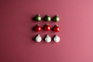 Christmas minimal composition. Christmas tree red, white decorations on burgundy background. Flat lay, top view.